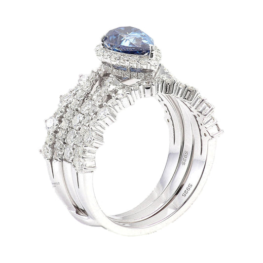 Fancy Blue Pear Moissanite Halo Engagement Ring Set from Carat and Kraft, on white